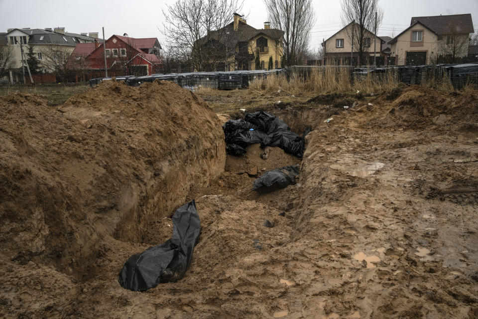 FILE - Bodies lie in a mass grave in Bucha, on the outskirts of Kyiv, Ukraine, April 3, 2022. The scenes that emerged from this town near Kyiv a year ago after it was retaken from Russian forces have indelibly linked its name to the savagery of war. Bodies of civilians lay where they had fallen, more bodies were found inside homes, others were unearthed from a mass grave. (AP Photo/Rodrigo Abd, File)