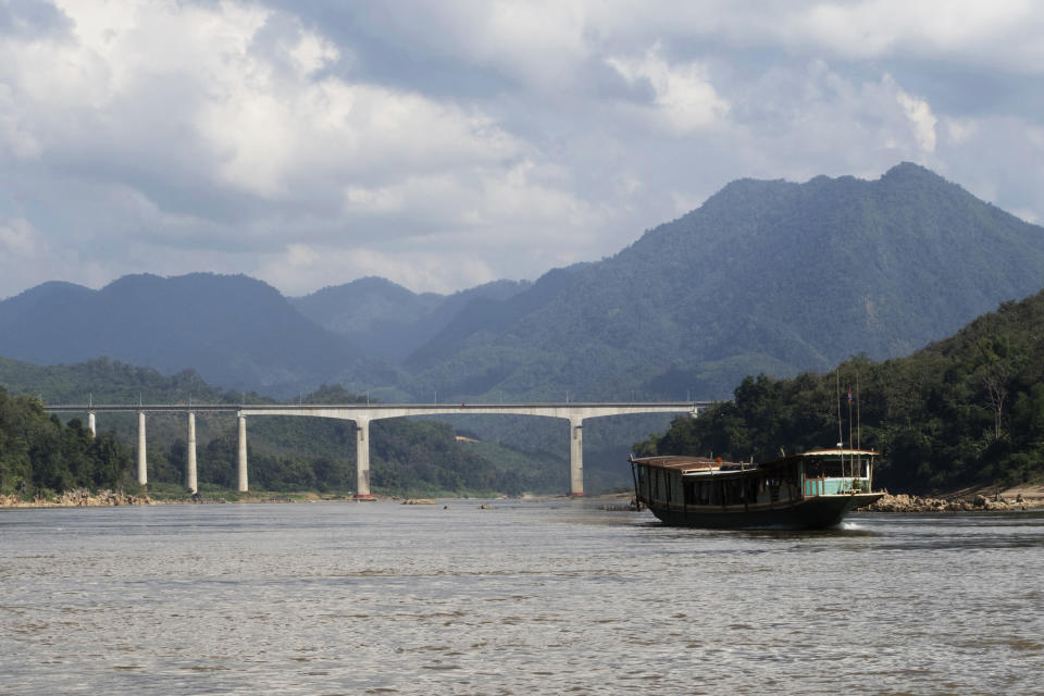 A boat moves across a bridge for the Chinese high-speed rail over the Mekong River, north of the Laotian city of Luang Prabang on Dec. 12, 2023. Laos has grown increasingly beholden to its giant neighbor to the north with massive amounts of debt to Chinese state banks for multiple infrastructure projects, including a new high-speed rail line across the country, said Muhammad Faizal, with the Institute of Defense and Strategic studies at the S. Rajaratnam School of International Studies in Singapore. (AP Photo/David Rising)