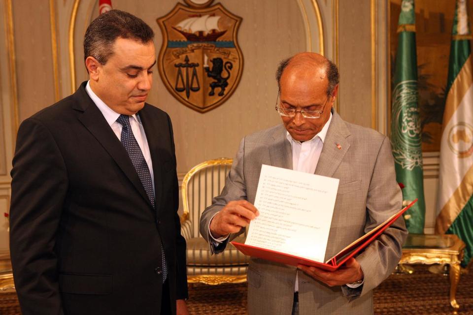 Interim Prime Minister, Mehdi Jomaa, left, presents the list of the members of his government to Tunisian President Moncef Marzouki during the new government presentation ceremony at the presidential palace in Carthage near Tunis, Sunday, Jan. 26, 2014. Tunisia's interim prime minister announced on Sunday his new government following a 24-hour delay over the post of interior minister. Mehdi Jomaa, the interim prime minister, had been working since Jan. 10 to form a government of technocrats to guide the country to new elections after a political crisis that began last year between Islamists and the opposition following the assassination of an opposition politician. (AP Photo/Hassene Dridi)