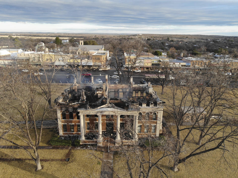 This drone photo provided by the Texas State Fire Marshal's Office, shows the aftermath of a fire at the Mason County Courthouse, Friday, Feb. 5, 2021, in Mason, Texas. An official says a suspect has been taken into custody following the massive fire Thursday that destroyed all but the rock outer walls of the 111-year-old courthouse. Fire investigators suspect arson in both the courthouse fire and a fire around the same time at a house about a mile away. (Texas State Fire Marshal's Office via AP)