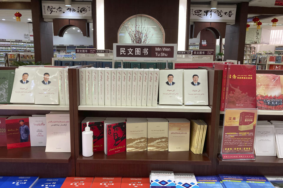 Uyghur-language copies of writings by Mao Zedong and Chinese President Xi Jinping sit on the shelves of the "ethnic minority language book" section of a bookstore in Aksu, in China's far west Xinjiang region, on March 18, 2021. Four years after Beijing's brutal crackdown on largely Muslim minorities native to Xinjiang, Chinese authorities are dialing back the region's high-tech police state and stepping up tourism. But even as a sense of normality returns, fear remains, hidden but pervasive. (AP Photo/Dake Kang)