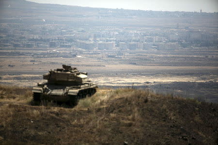 The Syrian area of Quneitra is seen in the background as an out-of-commission Israeli tank parks on a hill, near the ceasefire line between Israel and Syria, in the Israeli-occupied Golan Heights, August 21, 2015. Israel said it killed four Palestinian militants in an air strike on the Syrian Golan Heights on Friday, after cross-border rocket fire from Syria prompted the heaviest Israeli bombardment since the start of Syria's four-year-old civil war. REUTERS/Baz Ratner