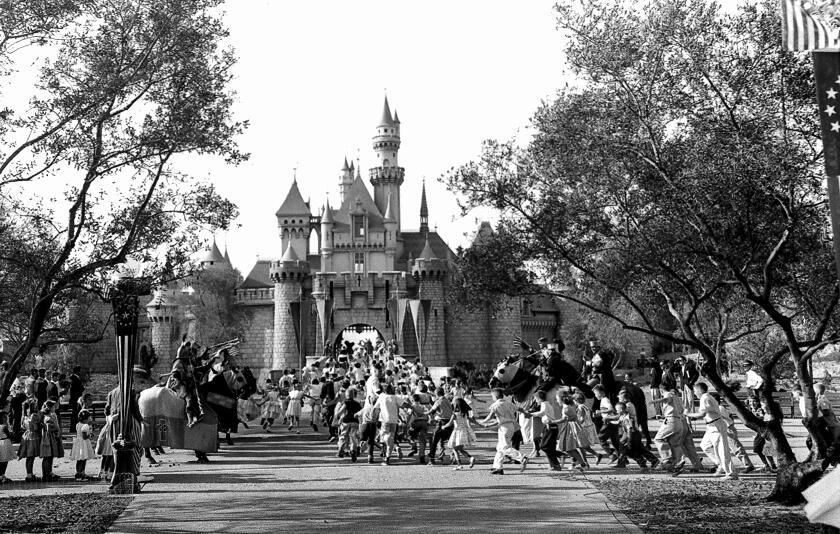 FILE - In this Sunday, July 17, 1955 file photo, children sprint across a drawbridge and into a castle that marks the entrance to Fantasyland at the opening of Walt Disney's Disneyland in Anaheim, Calif. Fantasyland had been closed until late in the day. (AP Photo)