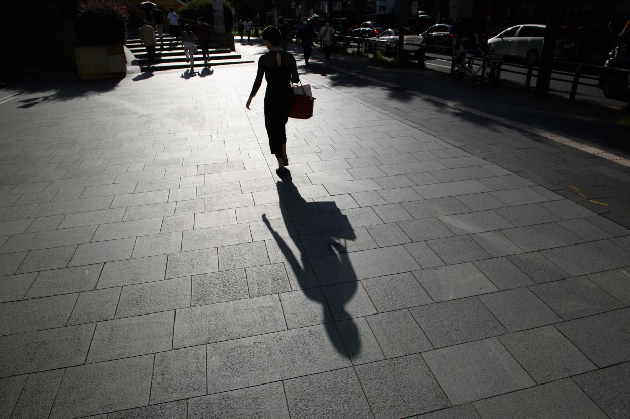 A silhouetted pedestrian near the Roppongi Hills complex in Tokyo, Japan, on Saturday, Oct. 1, 2022. (Akio Kon/Bloomberg)