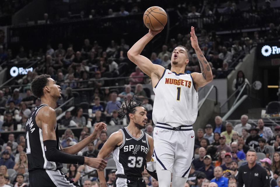 Denver Nuggets forward Michael Porter Jr., front right, shoots over San Antonio Spurs center Victor Wembanyama, left, and guard Tre Jones (33) during the first half of an NBA basketball game in San Antonio, Friday, April 12, 2024. (AP Photo/Eric Gay)