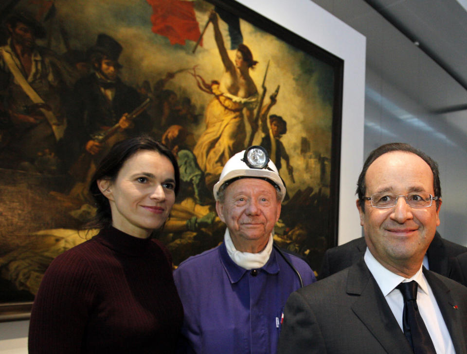 France's President Francois Hollande, right, is seen with Culture minister Aurelie Filippetti, left, and with a former miner, Lucien Laurent, centre, in front of " La Liberte Guidant le Peuple", a painting by Eugene Delacroix during the inauguration of the Louvre Museum in Lens, northern France, Tuesday, Dec. 4, 2012. The museum in Lens is to open on Dec. 12, as part of a strategy to spread art beyond the traditional bastions of culture in Paris to new audiences in the provinces. (AP Photo/Michel Spingler, Pool)