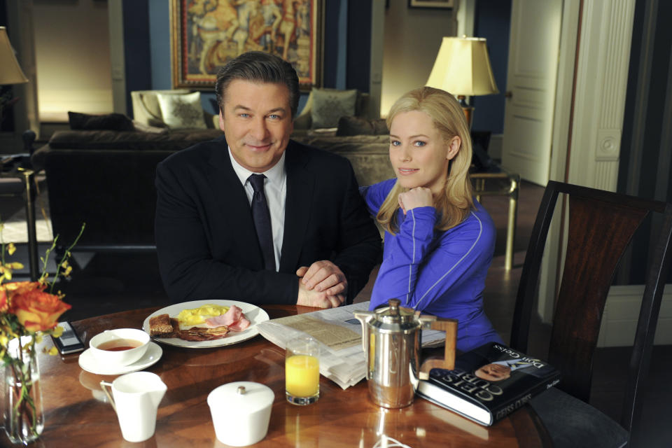 Alec Baldwin and Elizabeth Banks from the TV show "30 Rock" are sitting at a breakfast table in a scene