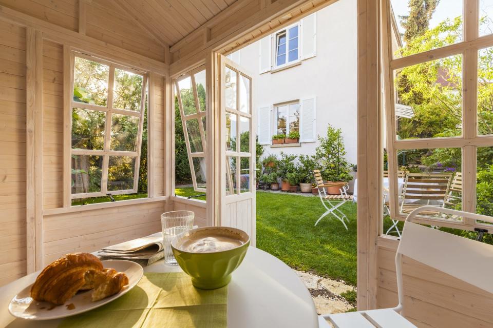 A table with a cooked meal on it inside of a room with doors and windows open.