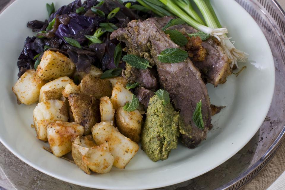 In this image taken on March 11, 2013, orange and mint-stuffed lamb with sweet-and-sour cabbage is shown served on a plate in Concord, N.H. (AP Photo/Matthew Mead)