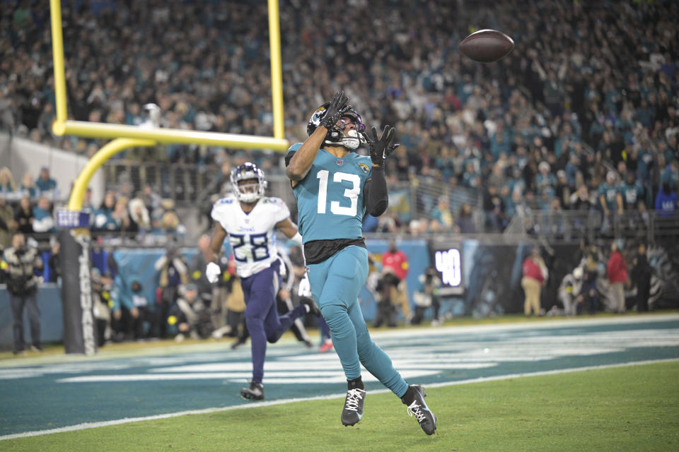 Jacksonville Jaguars wide receiver Christian Kirk (13) pulls in a touchdown reception in the first half of an NFL football game against the Tennessee Titans, Saturday, Jan. 7, 2023, in Jacksonville, Fla. (AP Photo/Phelan M. Ebenhack)