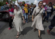 <p>A couple of nuns accompany Honduran migrants walking toward the U.S. as they arrive in Chiquimula, Guatemala, Tuesday, Oct. 16, 2018. (Photo: Moises Castillo/AP) </p>