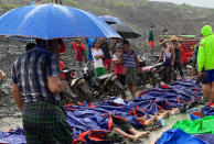 People gather near the bodies of victims of a landslide near a jade mining area in Hpakant, Kachin state, northern Myanmar Thursday, July 2, 2020. Myanmar government says a landslide at a jade mine has killed dozens of people. (AP Photo/Zaw Moe Htet)