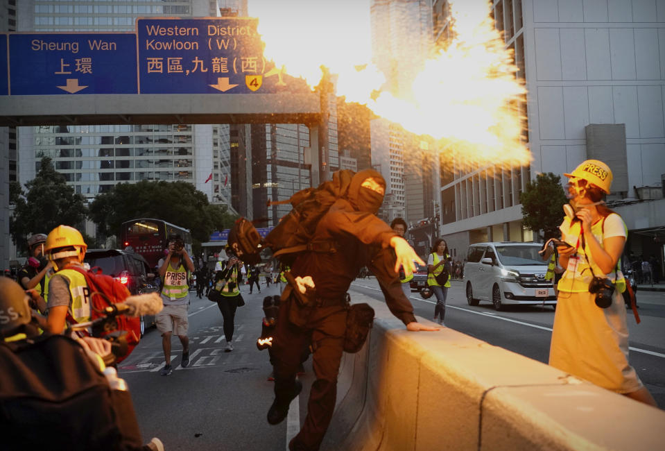 A demonstrator hurls a firebomb during a protest in Hong Kong, Saturday, Nov. 2, 2019. Anti-government protesters attacked the Hong Kong office of China's official Xinhua News Agency for the first time Saturday after chaos broke out downtown, with police and demonstrators trading gasoline bombs and tear gas as the protest movement approached the five-month mark. (AP Photo/Vincent Yu)
