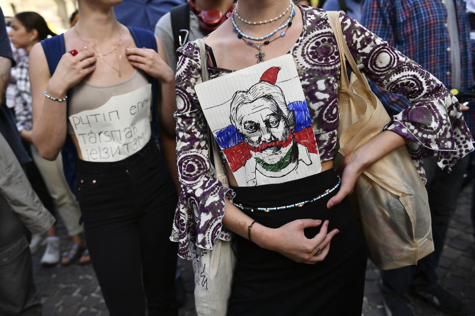 Hungarian students protest in solidarity with their teachers in front of the St. Stephen's Basilica in Budapest, Hungary, Friday, Sept. 2, 2022. The banner in the back says "I report to comrade Putin". Public schools in Poland and Hungary are facing a shortage of teachers at a time when both countries are taking in many Ukrainian refugee children. For years, teachers have been fleeing public schools over grievances regarding low wages and a sense of not being valued by their governments. (AP Photo/Anna Szilagyi)