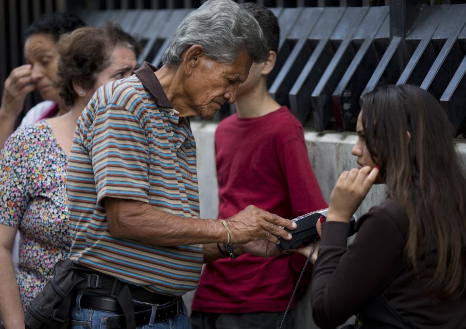 Un hombre compra huevos con su tarjeta de crédito en Caracas, Venezuela, sábado 18 de agosto de 2018. La oposición llamó a un paro nacional para el 21 de agosto en protesta por las medidas económicas que anunció el presidente Nicolás Maduro. (AP Foto/Ariana Cubillos)