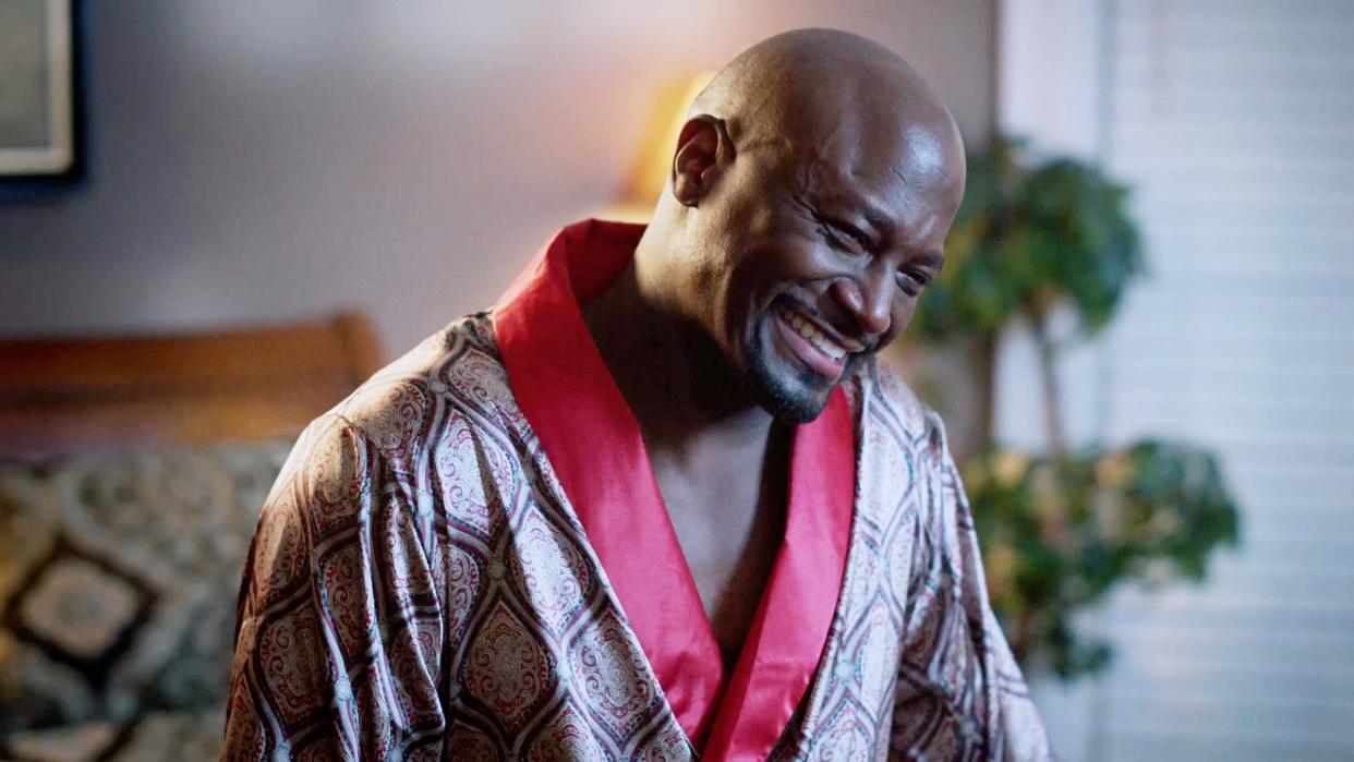  Taye Diggs as Lance smiling in a robe in Love & Murder: Atlanta Playboy. 