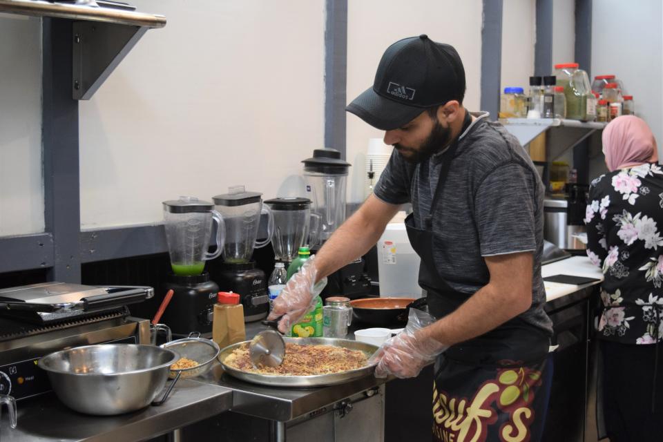 Co-owner Mohammed Zeid cuts an Imsakhan Pizza at Yusuf's Cuisine. The business opened for in-person dining in early May.