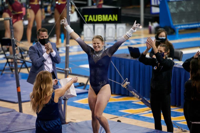 Sara Taubman salutes the judges after scoring a 9.825 on bars during UCLA's meet against Arizona State on Jan. 23, 2021.