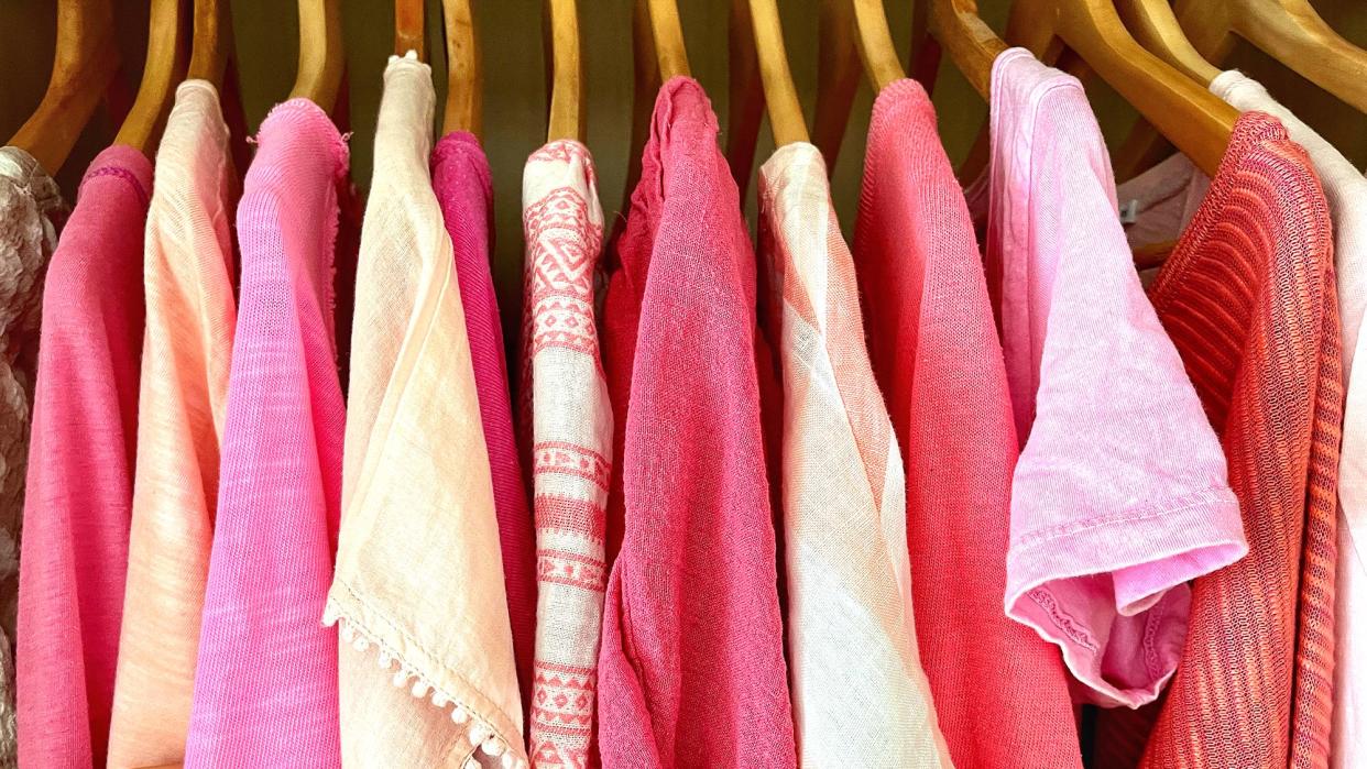 pink clothes hanging on wooden hangers