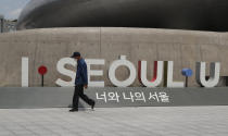 A man wearing a face mask walks in front of the display of South Korea's capital Seoul logo in Seoul, South Korea, Sunday, June 28, 2020. (AP Photo/Lee Jin-man)