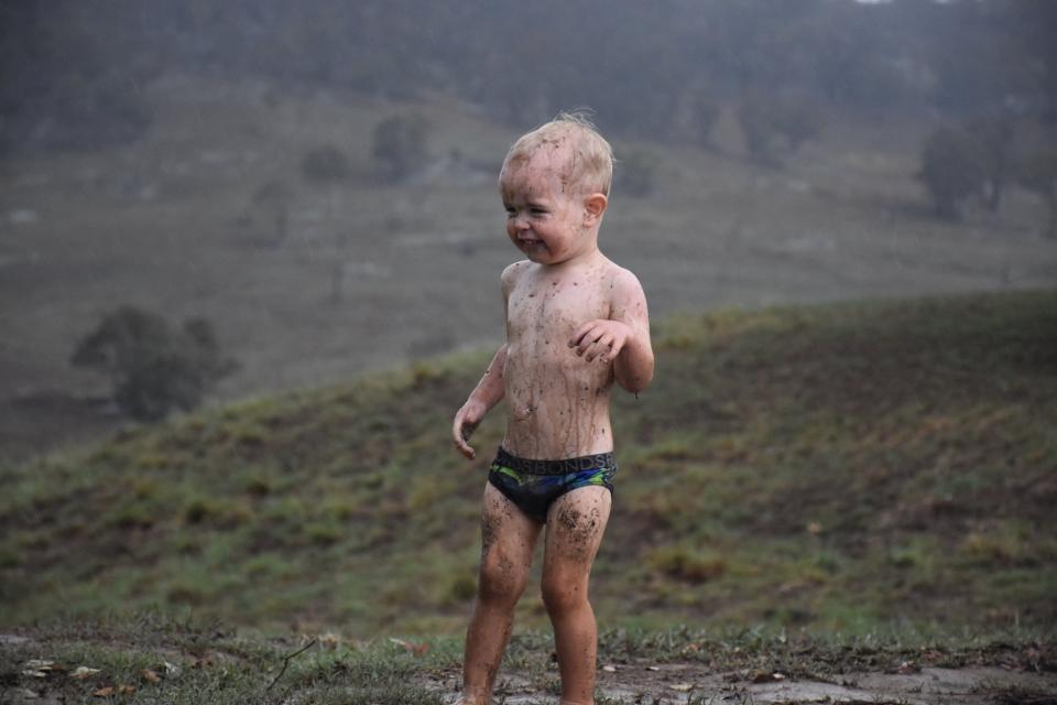 The two-year-old Wollomombi boy plays in the puddles after 20mm rainfall.