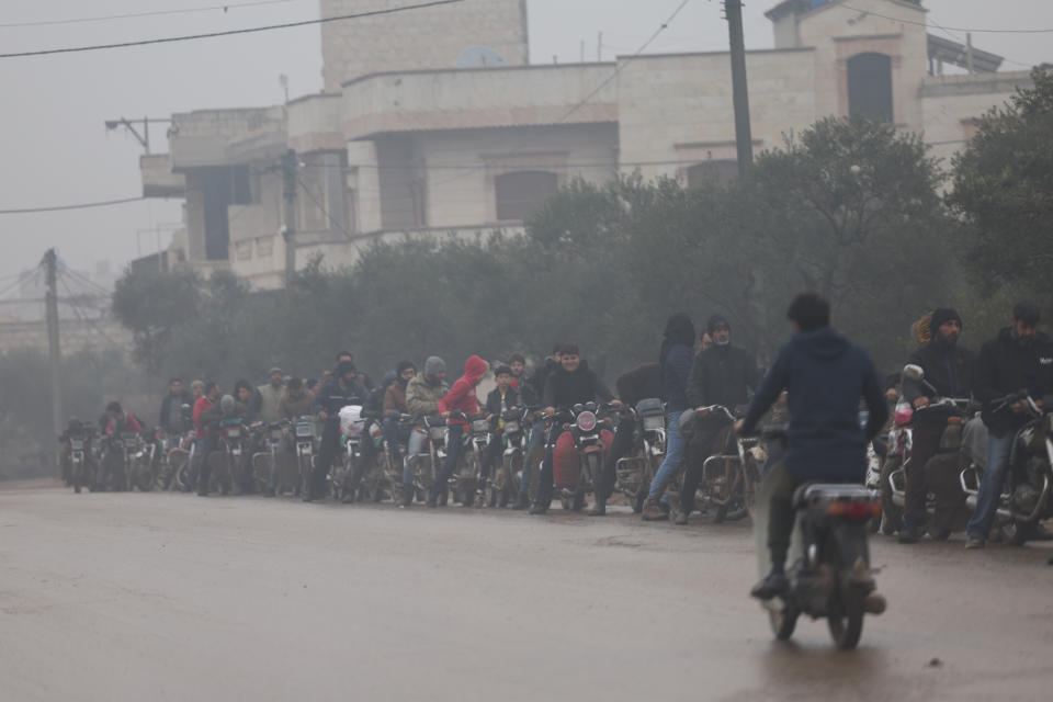 People queue up for gasoline in Idlib province, Syria, Sunday Dec. 15, 2022. Syria's economy has hit its lowest point since the country's civil war began nearly 12 years ago, with severe fuel shortages in both government and rebel-held areas, spiraling inflation and the Syrian currency hitting an all-time low on the black market. (AP Photo/Ghaith Alsayed)