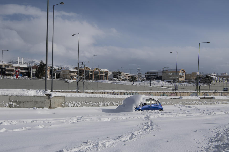 An abandoned vehicle, is seen in an motorway way after a snowstorm, in Athens, on Tuesday, Jan. 25, 2022. Army and fire service teams were deployed late Monday to extract hundreds of motorists trapped for hours in snowed-in cars. A snowstorm of rare severity disrupted road and air traffic Monday in the Greek capital of Athens and neighboring Turkey's largest city of Istanbul, while most of Greece, including — unusually — several Aegean islands, and much of Turkey were blanketed by snow. (AP Photo/Michael Varaklas)