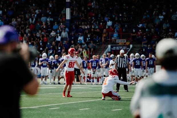 SFU football player Kristie Elliott, pictured here, gets ready to kick the ball for a point against Linfield University in September 2021. She's the first Canadian woman to play in, and score in, a college game. (Linfield Athletics - image credit)