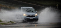 A car plows through high water at the intersection of Williamsburg Rd. and E. Main St. as the remnants of Hurricane Sally swept into the Richmond, Va., area Thursday, Sept. 17, 2020. (Bob Brown/Richmond Times-Dispatch via AP)