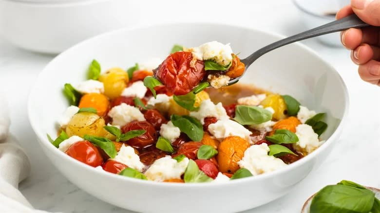 Roasted tomato caprese salad in white bowl