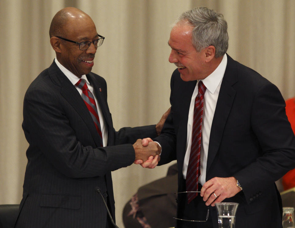 Dr. Michael Drake, left, the incoming president at Ohio State University, shakes hands with Robert Schottenstein, chairman of the Ohio State University board, after Drake was named president during the board meeting Wednesday, Jan. 30, 2014. (AP Photo/Paul Vernon)