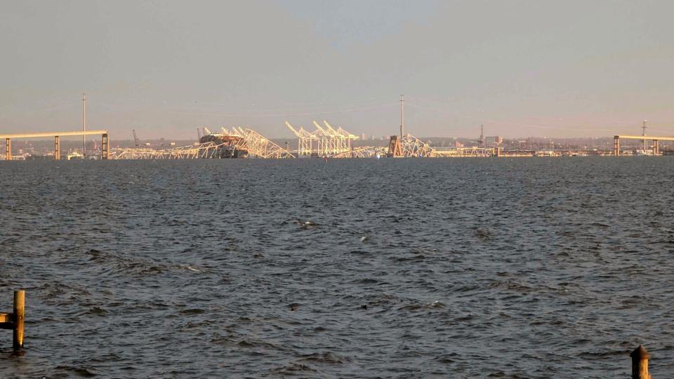 Baltimore's Francis Scott Key Bridge collapse is shown early morning, Tuesday, March 26, 2024 from Riviera Beach, Md. A container ship rammed into a major bridge in Baltimore early Tuesday, causing it to snap in a few places and plunge into the river below. Several vehicles fell into the chilly waters, and rescuers were initially searching for at least seven people. (AP Photo/Nathan Ellgren)