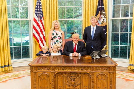 U.S. President Donald Trump and Vice President's Chief of Staff Nick Ayers (R) and his wife Jamie Floyd with their children pose for pictures in the Oval Office at the White House in this social media photo released by Vice President Mike Pence's office in Washington, DC, U.S., on July 28, 2017. Courtesy Vice President's office/Handout via REUTERS