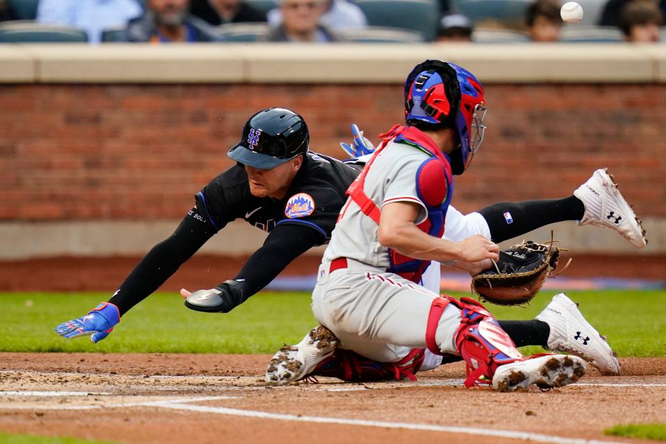 New York Mets' Brandon Nimmo slides past Philadelphia Phillies catcher Garrett Stubbs to score on a sacrifice fly by Pete Alonso during the first inning of a baseball game Friday, May 27, 2022, in New York. (AP Photo/Frank Franklin II)