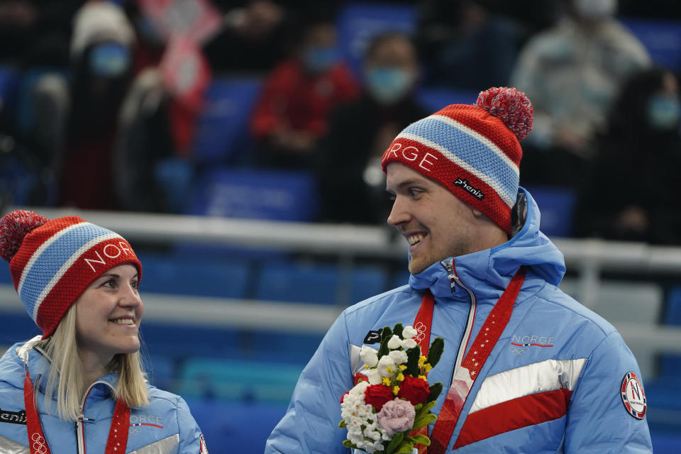 Silver medalist Kristin Skaslien, left, and her husband and teammate Magnus Nedregotten, both of Norway, look at each other during the venue ceremony for the mixed doubles curling match against Italy at the Beijing Winter Olympics Tuesday, Feb. 8, 2022, in Beijing. (AP Photo/Brynn Anderson)