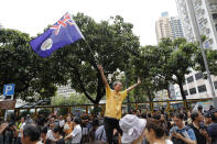 A man waves a colonial British-era Hong Kong flag as people gather at a public park ahead of a planned demonstration in Hong Kong, Saturday, Aug. 3, 2019. Hong Kong police on Saturday called on protesters to stick to designated routes and times after violent clashes marred the last eight weekends of rallies calling for greater rights and government accountability. (AP Photo/Vincent Thian)