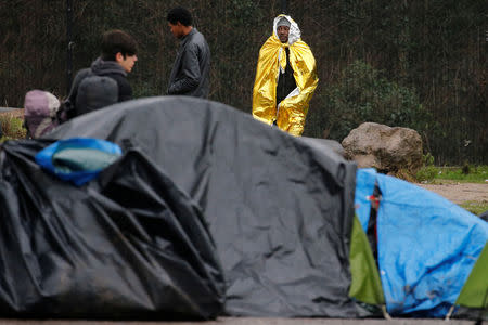 A migrant from Chad keeps warm with a space blanket, after the dismantling of a camp in Calais, France, January 10, 2019. Picture taken January 10, 2019. REUTERS/Pascal Rossignol