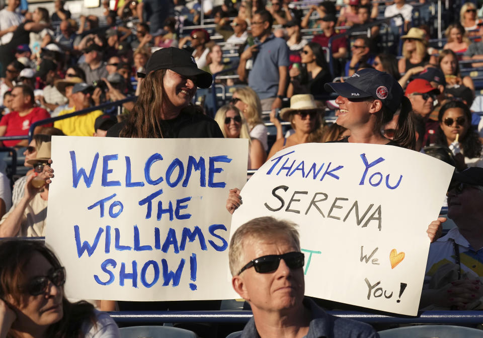 Fans hold signs as Serena Williams, of the United States, arrives on court for a match against Belinda Bencic, of Switzerland, during the National Bank Open tennis tournament Wednesday, Aug. 10, 2022, in Toronto. (Nathan Denette/The Canadian Press via AP)