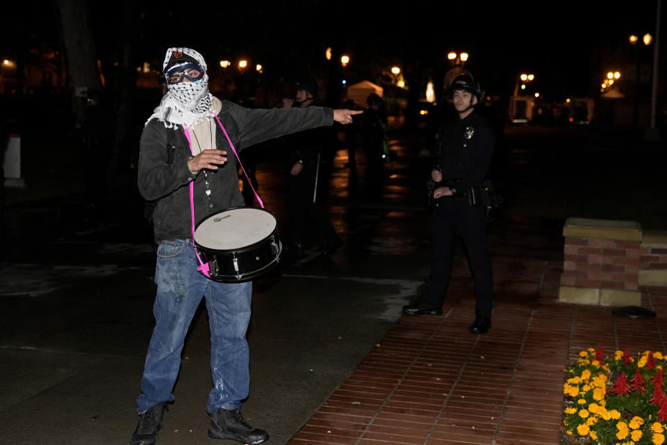 A protestors gestures near police officers after a raid on the pro-Palestinian encampment on the campus at the University of Southern California Sunday, May 5, 2024, in Los Angeles. (AP Photo/Ryan Sun)