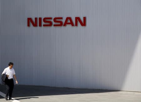 A man walks past the logo of Nissan Motor Co. at the company's showroom in Yokohama, south of Tokyo May 13, 2015. REUTERS/Toru Hanai