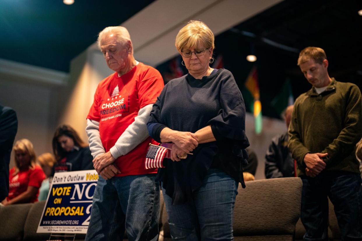 People bow their heads for prayer at a church.