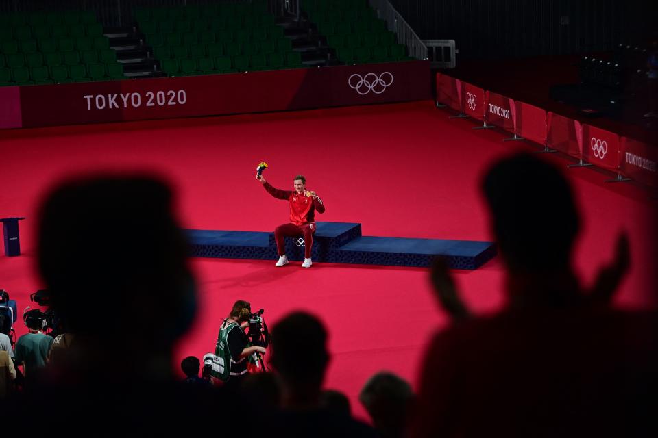 <p>TOPSHOT - Denmark's Viktor Axelsen is applauded with his men's singles badminton gold medal at a ceremony during the Tokyo 2020 Olympic Games at the Musashino Forest Sports Plaza in Tokyo on August 2, 2021. (Photo by Pedro PARDO / AFP) (Photo by PEDRO PARDO/AFP via Getty Images)</p> 