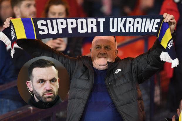 A Scotland fan shows his support for the people of Ukraine and, inset, James McFadden