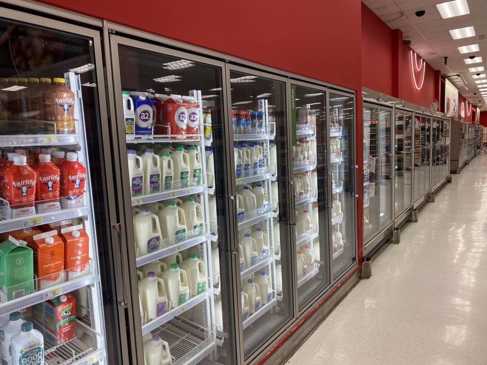 The refrigerators at the back of the store of a target filled with milk