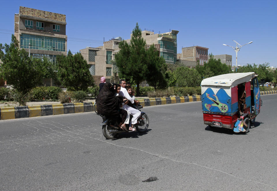 An Afghan family travels on a motorcycle during fighting between Taliban and Afghan security forces in Herat province, west of Kabul, Afghanistan, Sunday, Aug. 1, 2021. (AP Photo/Hamed Sarfarazi)