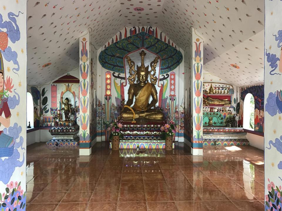 CORRECTS DATE OF PHOTO - In this Dec. 2, 2016 photo, a colorful temple marks the entrance to Wat Pha Lat temple outside Chiang Mai, Thailand. The complex is tucked in a forest overlooking the city and can be reached by hiking the Monks Trail, which is marked by strips of orange cloth. (AP Photo/Courtney Bonnell)