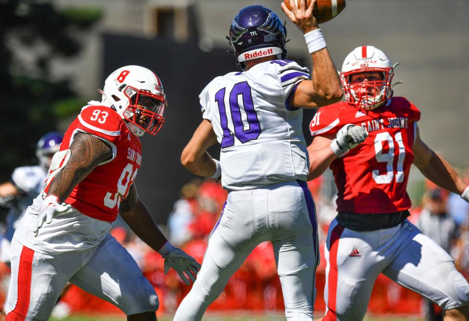 Metoriah Faoliu and Michael Wozniak of St. John's concentrate on Whitewater quarterback Evan Lewandowski during the first half of the game Saturday, Sept. 3, 2022, at Clemens Stadium in Collegeville. 