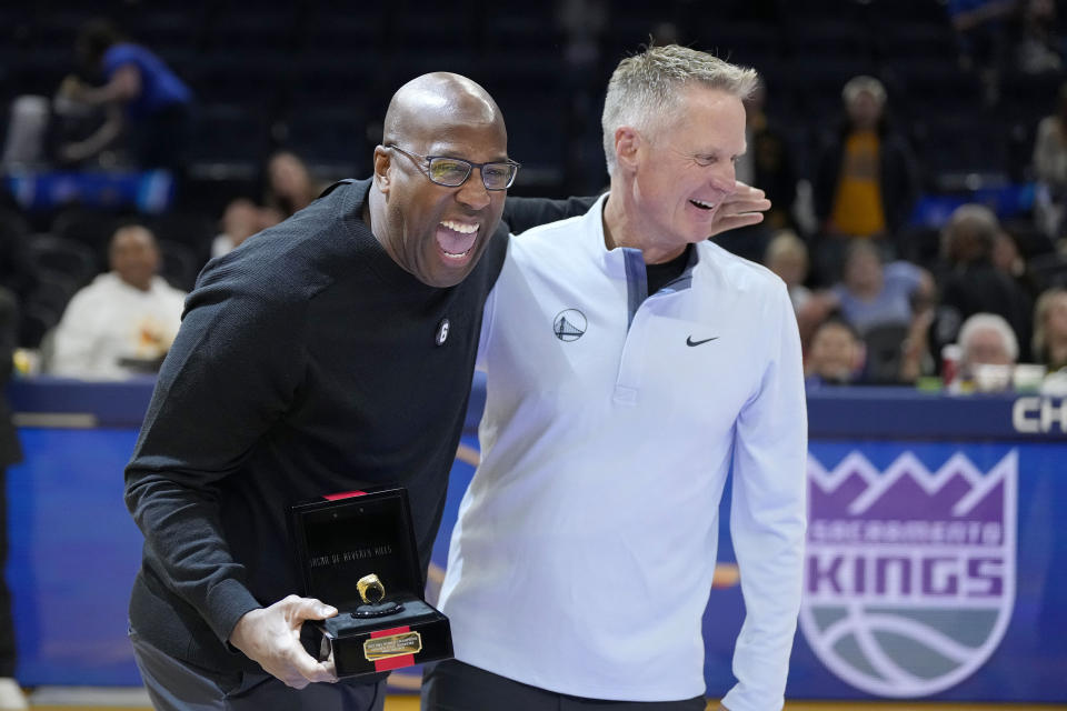 Golden State Warriors head coach Steve Kerr, right, laughs with former Warriors assistant coach and Sacramento Kings head coach Mike Brown, left, after Brown received his 2021-2022 NBA Championship ring before an NBA basketball game between the Warriors and the Kings, Sunday, Oct. 23, 2022, in San Francisco. (AP Photo/Tony Avelar)