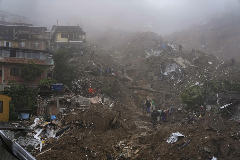 Rescue workers and residents look for victims in an area damaged by landslides in Petropolis, Brazil, Wednesday, Feb. 16, 2022. Extremely heavy rains set off mudslides and floods in a mountainous region of Rio de Janeiro state, killing multiple people, authorities reported. (AP Photo/Silvia Izquierdo)