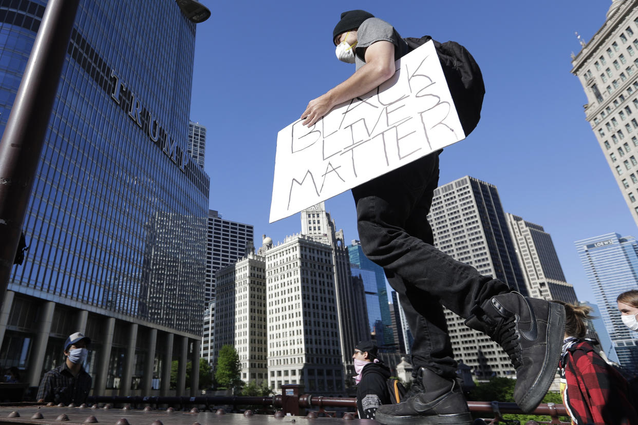 A protester holds a sign as he marches to Trump Tower